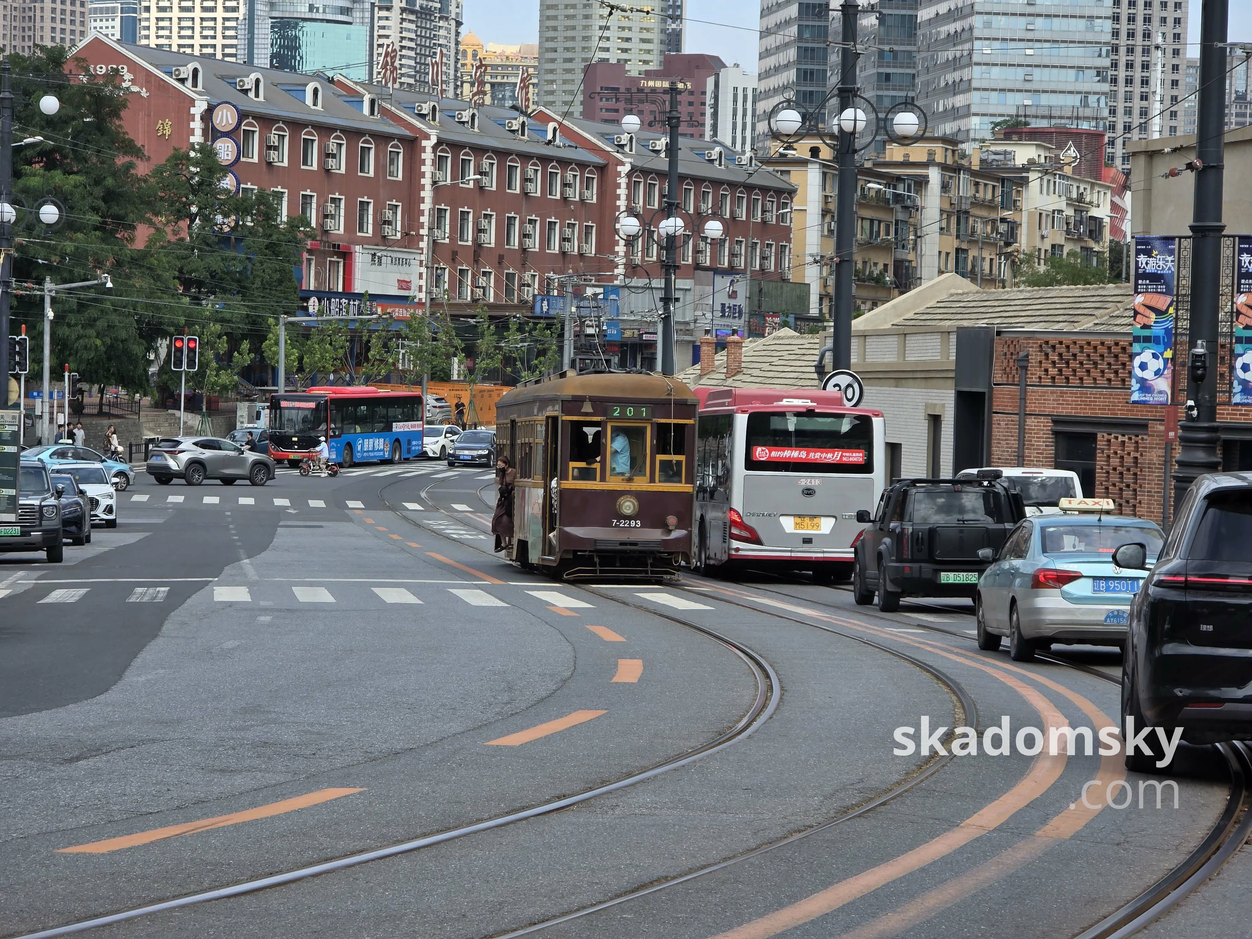 一辆棕色单节电车迎着车流向上驶来。