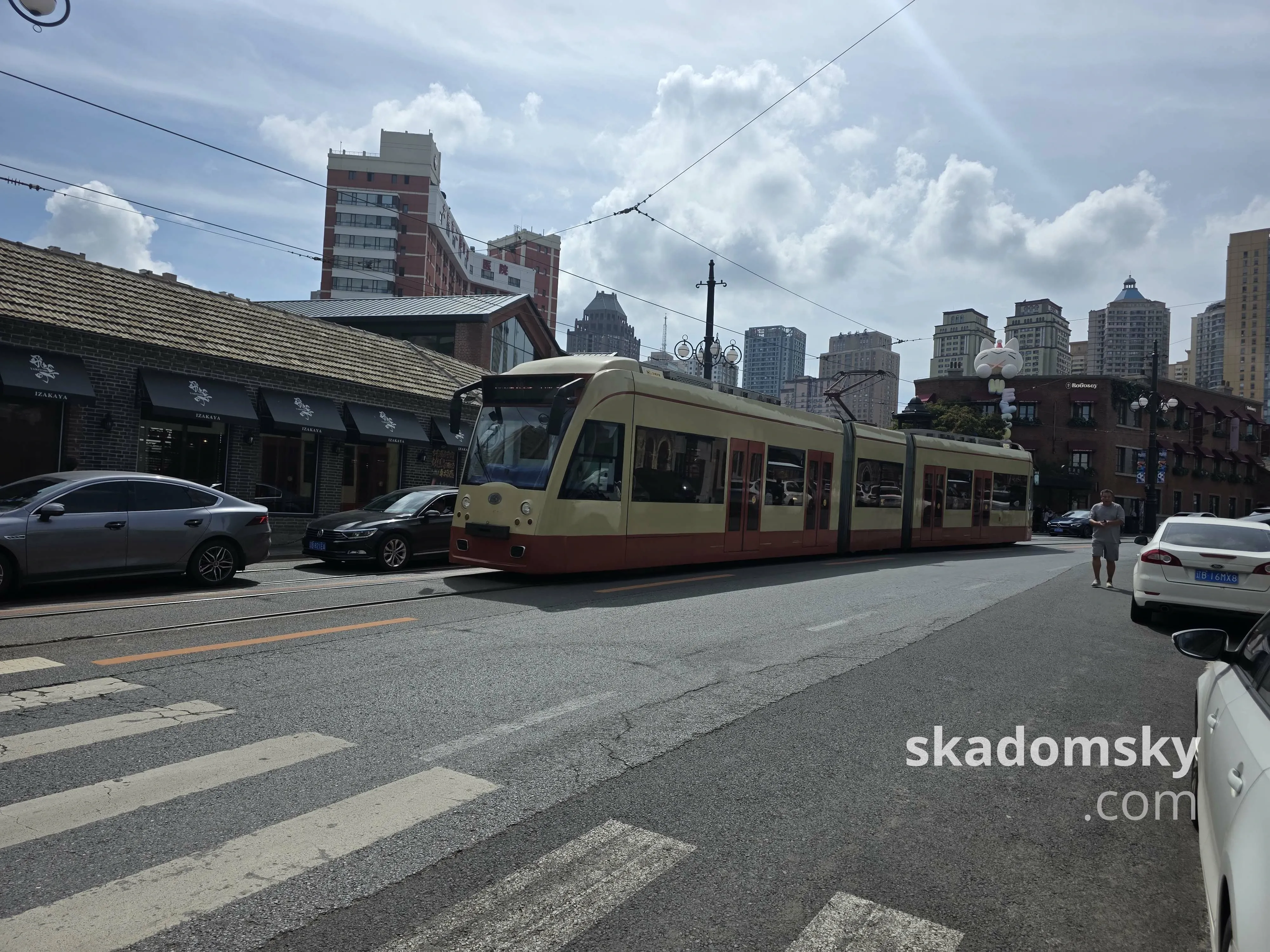 在路边停靠的有轨电车。空旷的道路两旁停放着不少轿车。